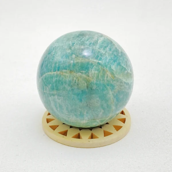 The Amazonite Sphere supports heartfelt communication, emotional balance, and gentle transformation. With its soothing blue-green tones, it encourages honest self-expression while easing fear around change. Resting on its round base, this sphere radiates calm confidence, helping you move forward with clarity and trust.