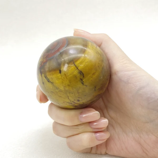 The Tiger’s Eye Sphere radiates confidence, courage, and focused determination. Its steady, empowering energy supports clear communication and self-belief during moments of challenge or change. Resting on its round base, it anchors motivation and strength in any space.