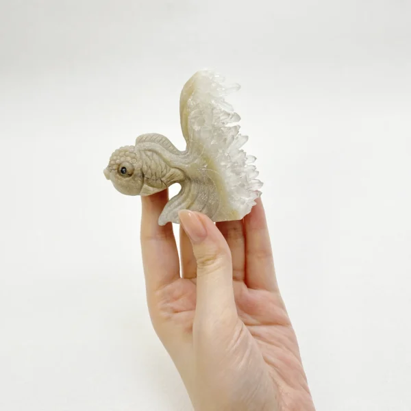 A symbolic Hand-Carved Clear Quartz Cluster Goldfish representing abundance, clarity, and spiritual protection. Crafted from natural clear quartz, this carving amplifies intention while harmonizing and grounding energy across all chakras.