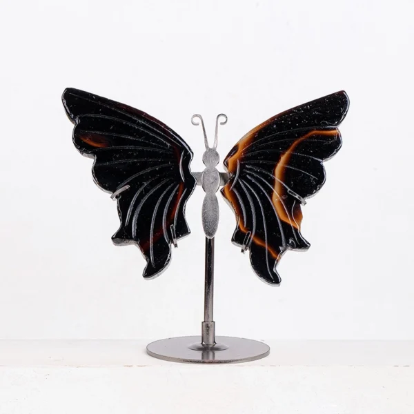 Carved from deep black agate, this Crystal Butterfly sculpture embodies grounding strength and graceful transformation. Resting on a refined metal stand, it anchors your space with protective energy while symbolizing the courage to release the past and embrace profound change. A powerful spiritual accent for moments of transition.